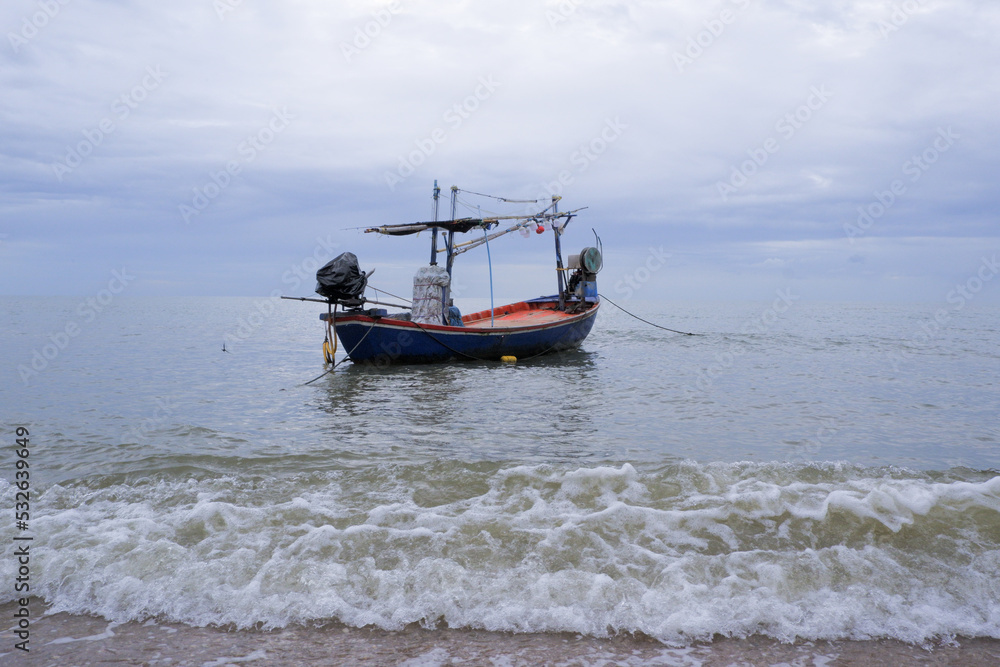 Fototapeta premium Fishermen's boats stop at the beach, where there is sand and waves.