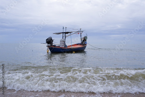 Fishermen's boats stop at the beach, where there is sand and waves.