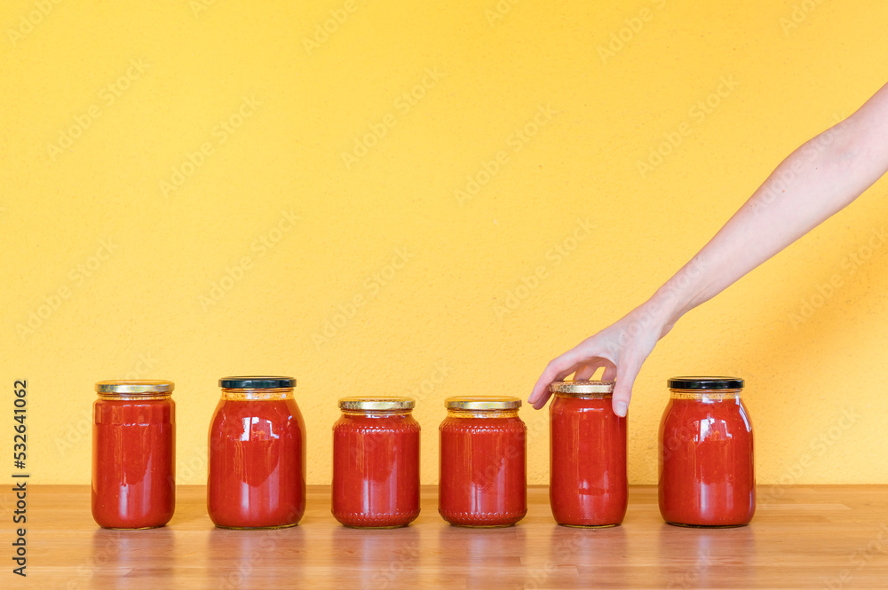 Hand holds a tomato passata sauce bottle Hand holds a tomato passata sauce bottle