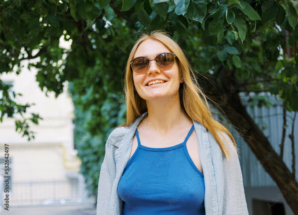 Happy young blond woman near her house Happy young blond woman near her house