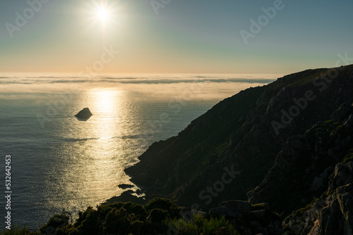 Sailboat sailing at sunset along Finisterre Cape, Atlantic Ocean  photo