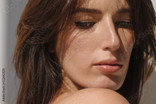 Closeup portrait of brunette woman in sunlight