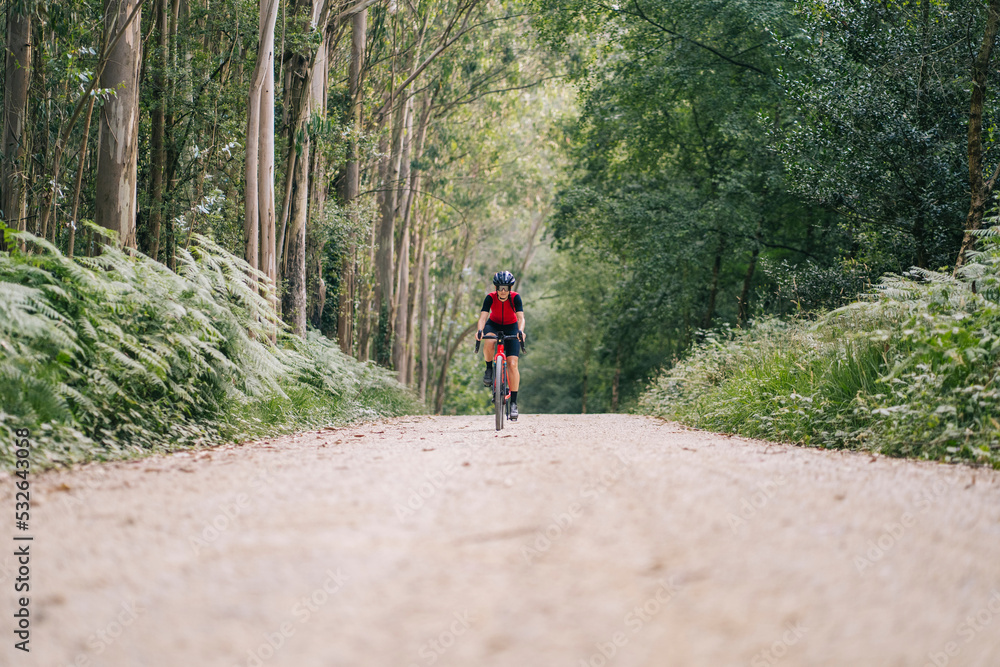 Bicyclist riding on empty road in countryside Bicyclist riding on empty road in countryside