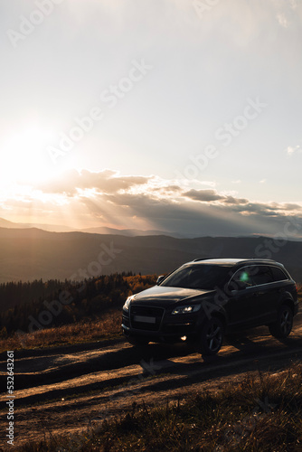 Car truck is going up on road in mountains during autumn sunset time © Yurii Kushniruk