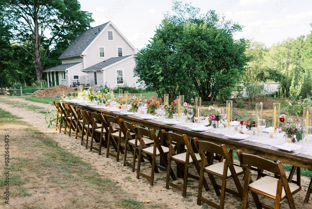 View of a long event table with decor and flower arrangements View of a long event table with decor and flower arrangements