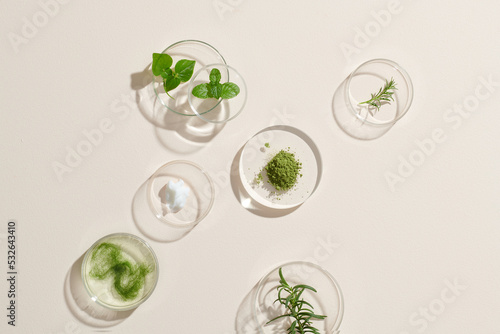 Cream and natural ingredients on white table in cosmetic laboratory