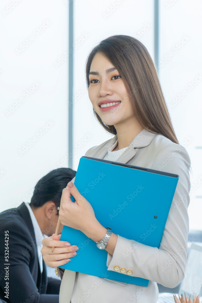Beautiful Asian businesswoman standing near glass window. Beautiful Asian businesswoman standing near glass window.