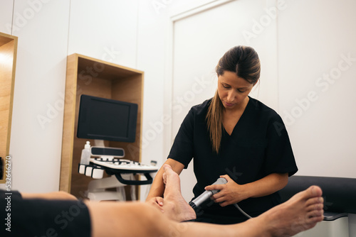 Rehabilitation treatment with shock waves in a physiotherapy clinic photo