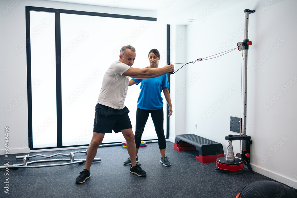 Physiotherapist working in a rehabilitation gym Physiotherapist working in a rehabilitation gym