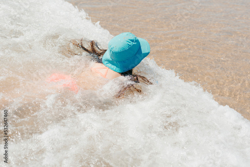 Little girl swimming on the shore photo