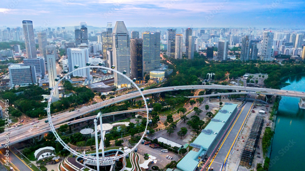 Naklejka premium Singapore flyer with skyscraper at morning