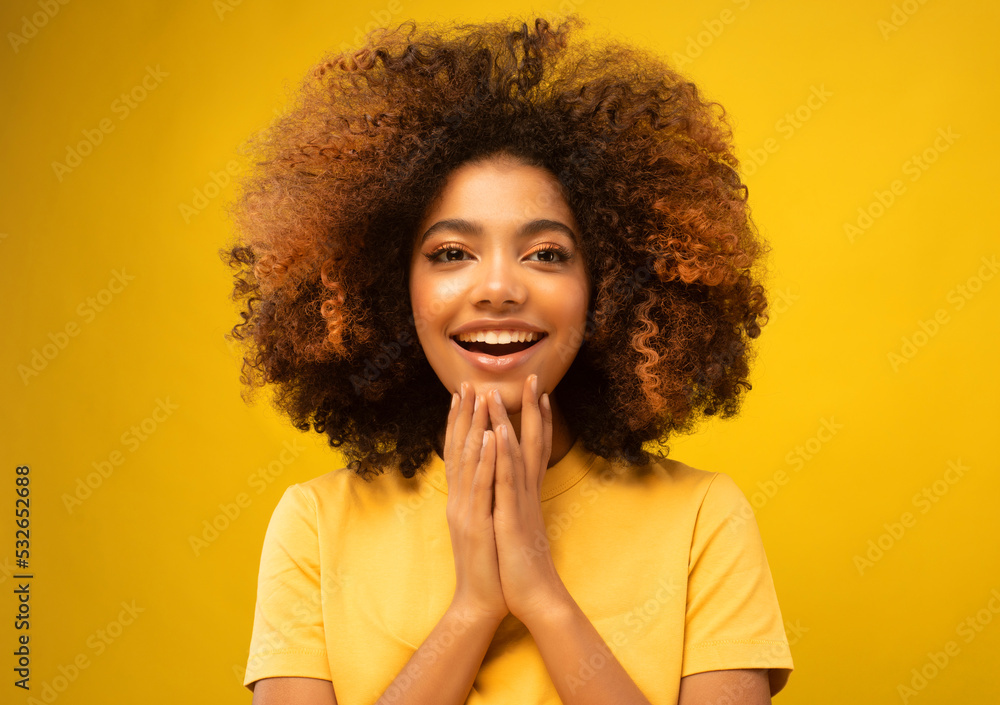 Young African Woman Surprised Smiling at Camera on Yellow Background. Young African Woman Surprised Smiling at Camera on Yellow Background.