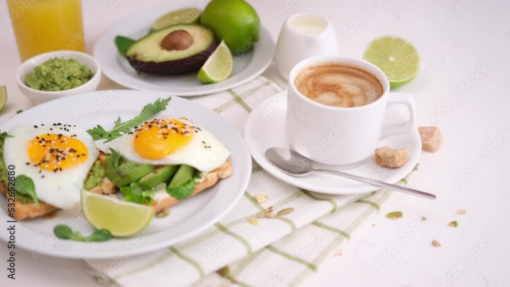 Cup of hot coffee and freshly made healthy Toast with avocado and fried egg for breakfast Cup of hot coffee and freshly made healthy Toast with avocado and fried egg for breakfast