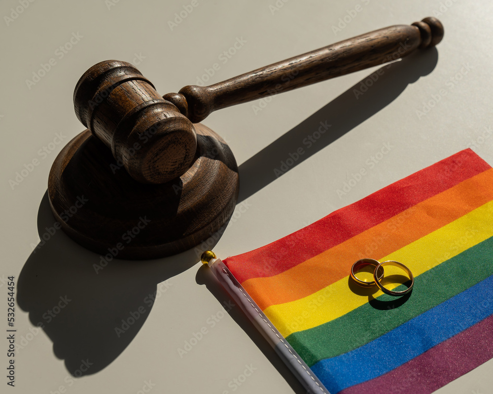 Legalization of same-sex marriages. Rainbow flag wedding rings and judge's gavel. 