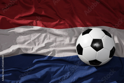 vintage football ball on the waveing national flag of netherlands background. 3D illustration