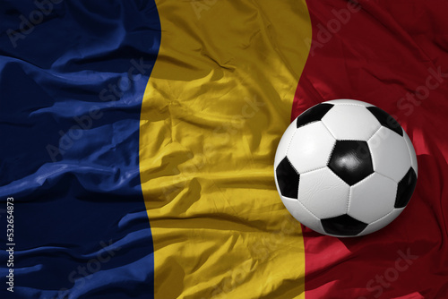 vintage football ball on the waveing national flag of romania background. 3D illustration