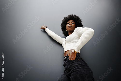 Fotobehang Fashionable young beautiful woman with hairstyle posing on the black wall