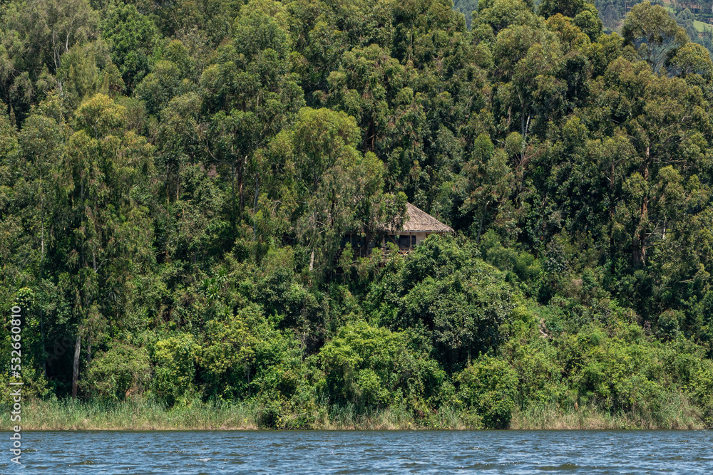 Beautiful landscape of a house tucked between the trees on an island in Lake Bunyonyi in Uganda, Africa