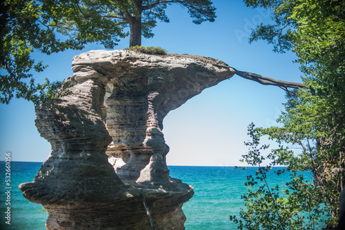 Pictured Rocks cliffs with the tree growing on the rock in the Upper Peninsula of Michigan near the city of Munising on a clear summer day.