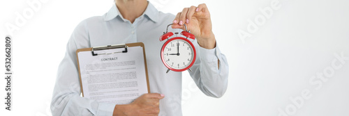 Slika na platnu Businesswoman holding contract and alarm clock closeup