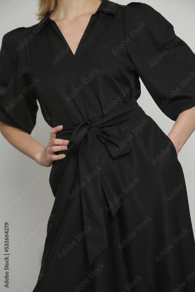 Fototapeta premium Serie of studio photos of young female model in black viscose midi dress