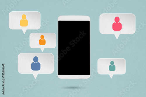 Fototapeta Naklejka Na Ścianę i Meble -  Concept of online communication or social networking. Mobile phone and grunge white  speech bubbles paper cut with multi color people icon on grunge background