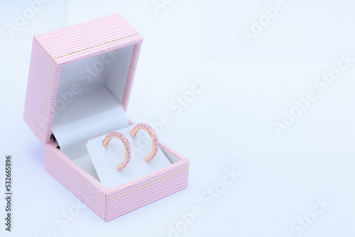 Pink sapphire earring in pink jewelry box on white background. Precious gift or present for special event