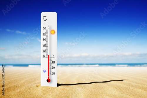 Hot summer day. Celsius scale thermometer in the sand. Ambient temperature plus 5 degrees