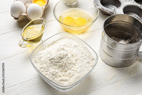 Different ingredients for baking on white wooden table, closeup