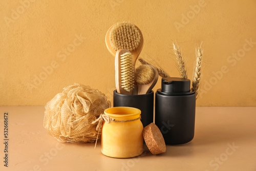 Set of bath supplies with different massage brushes on color background