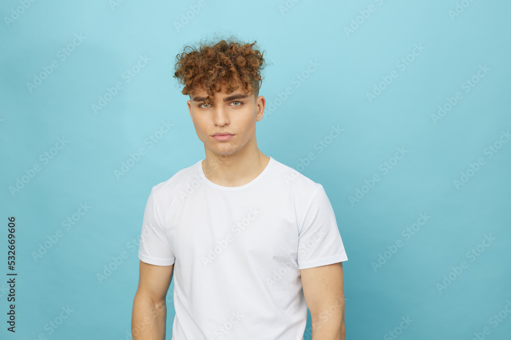 horizontal isolated portrait of a handsome man with curly hair smiling pleasantly at the camera while standing in a casual white T-shirt horizontal isolated portrait of a handsome man with curly hair smiling pleasantly at the camera while standing in a casual white T-shirt