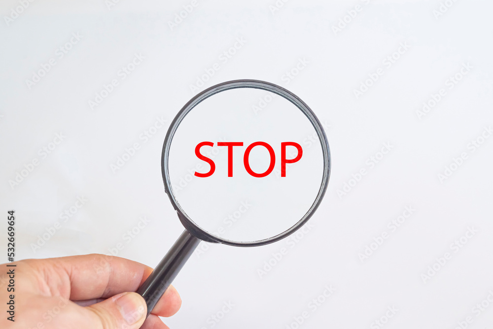 Stop text in magnifying glass.
hand holding a magnifying glass.
Detective and Search risk Idea Concept. Stop text in magnifying glass.
hand holding a magnifying glass.
Detective and Search risk Idea Concept.