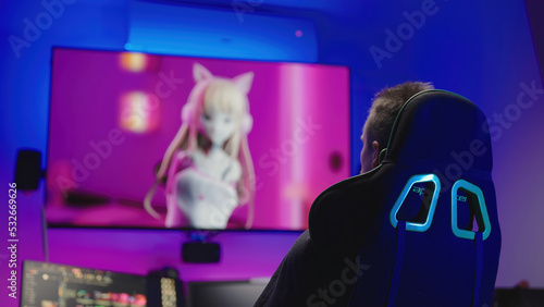 Anime tv show on big television in cyberspace room with man on gaming chair photo