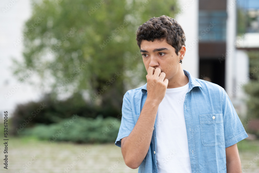 Worried and concerned hispanic boy thinking hand on mouth. Worried and concerned hispanic boy thinking hand on mouth.