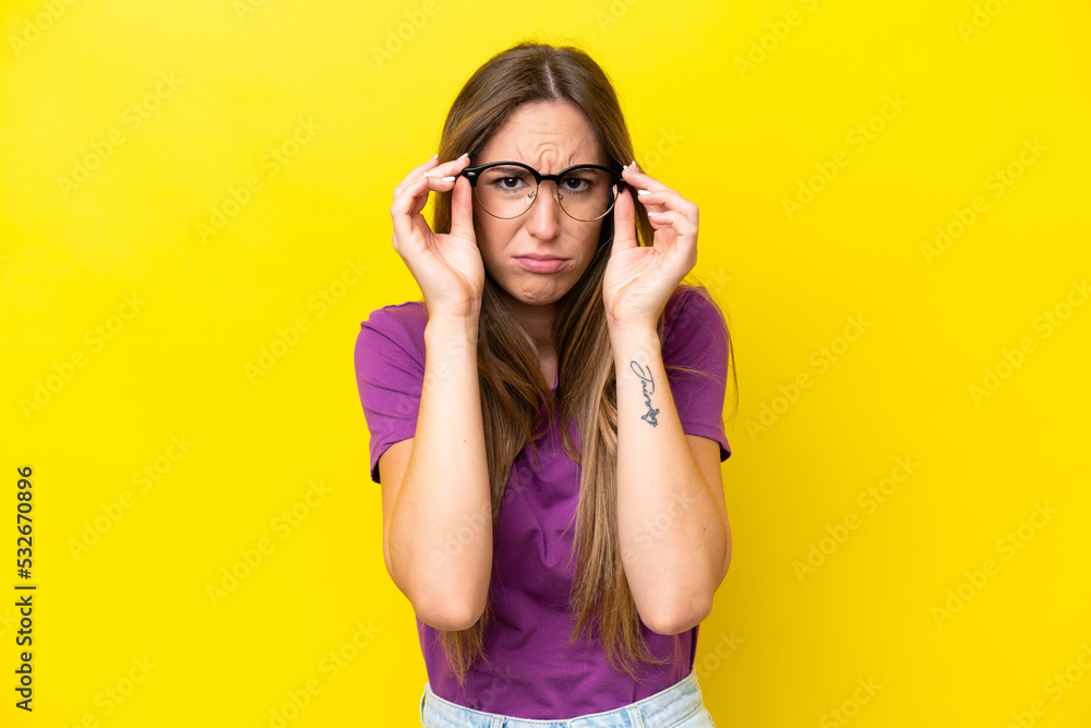 Young caucasian woman isolated on yellow background With glasses and frustrated expression Young caucasian woman isolated on yellow background With glasses and frustrated expression