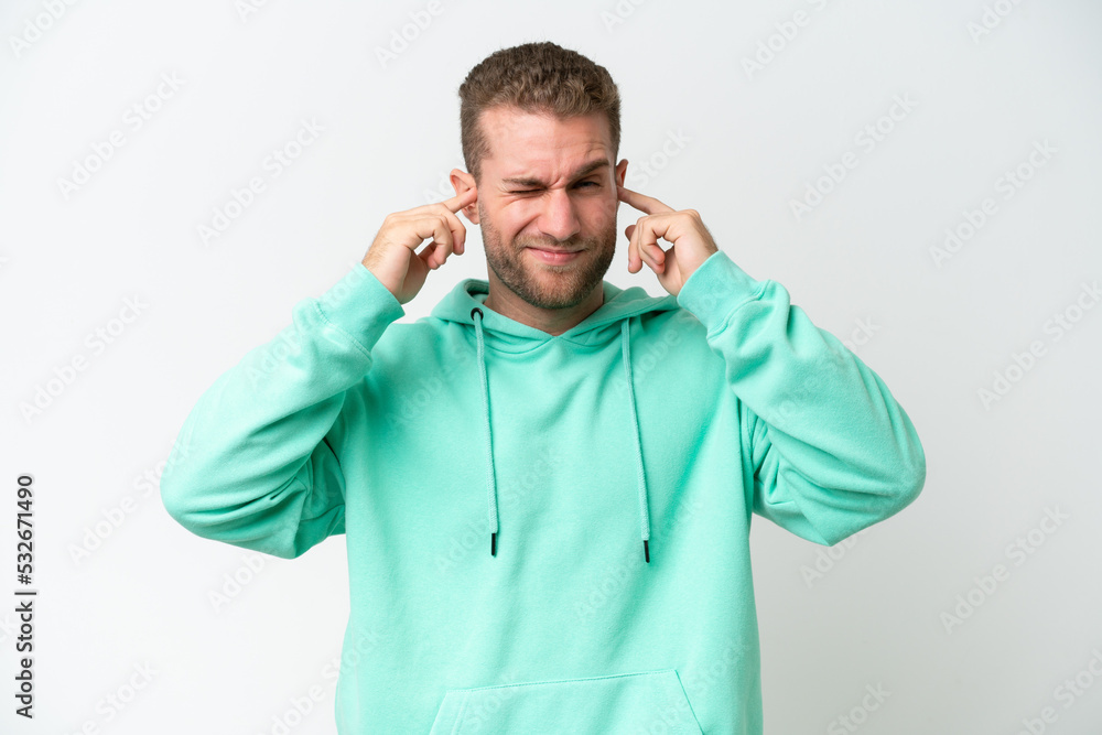 Young handsome caucasian man isolated on white background frustrated and covering ears Young handsome caucasian man isolated on white background frustrated and covering ears