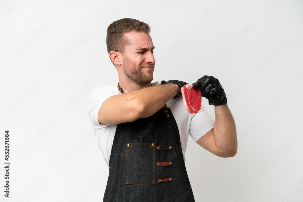 Butcher caucasian man wearing an apron and serving fresh cut meat isolated on white background suffering from pain in shoulder for having made an effort Butcher caucasian man wearing an apron and serving fresh cut meat isolated on white background suffering from pain in shoulder for having made an effort
