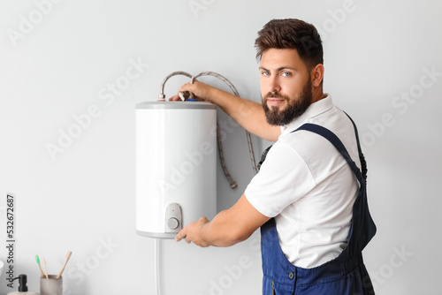 Male plumber installing boi...