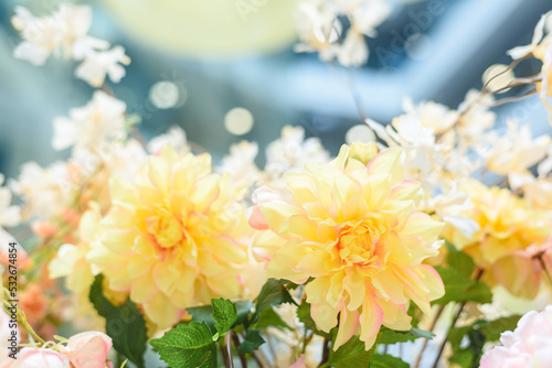 Yellow artificial dahlias flowers decorating shopping mall with color and brightness. Building premise decoration to attract attention