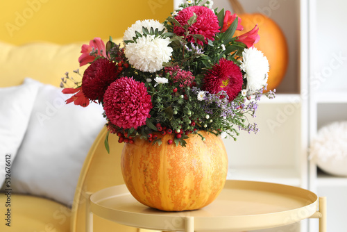 Autumnal floral arrangement in pumpkin vase, thanksgiving and fall season decor, cozy home interior