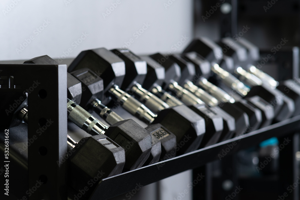 Naklejka premium Dumbbell home blurry wall gym set storage strongman equipment, from studio gear in training and muscular strong, weight hard. Weightlifting ,