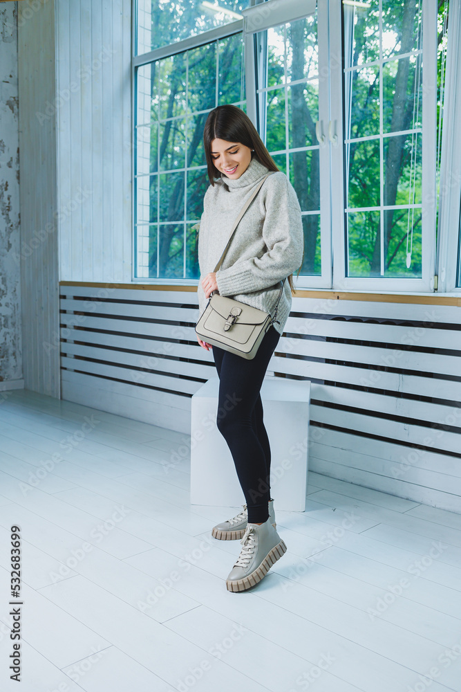 Photo of a young woman in white boots and casual clothes. New collection of women's winter shoes made of genuine leather.