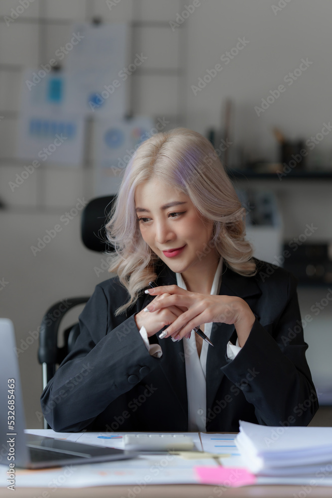 Beautiful Asian businesswoman analyzes financial charts. Account and audit concept Beautiful Asian businesswoman analyzes financial charts. Account and audit concept