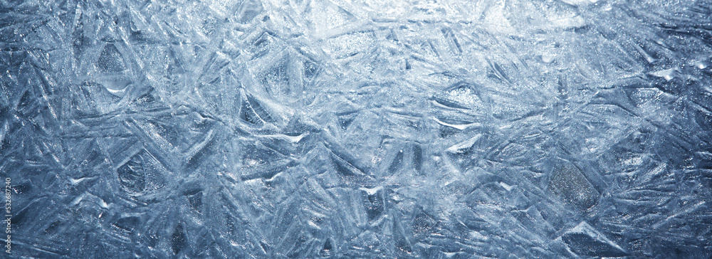 The texture of the ice surface. Winter background, festive background in the form of ice crystals, in natural deep blue color. The texture of the ice surface. Winter background, festive background in the form of ice crystals, in natural deep blue color.