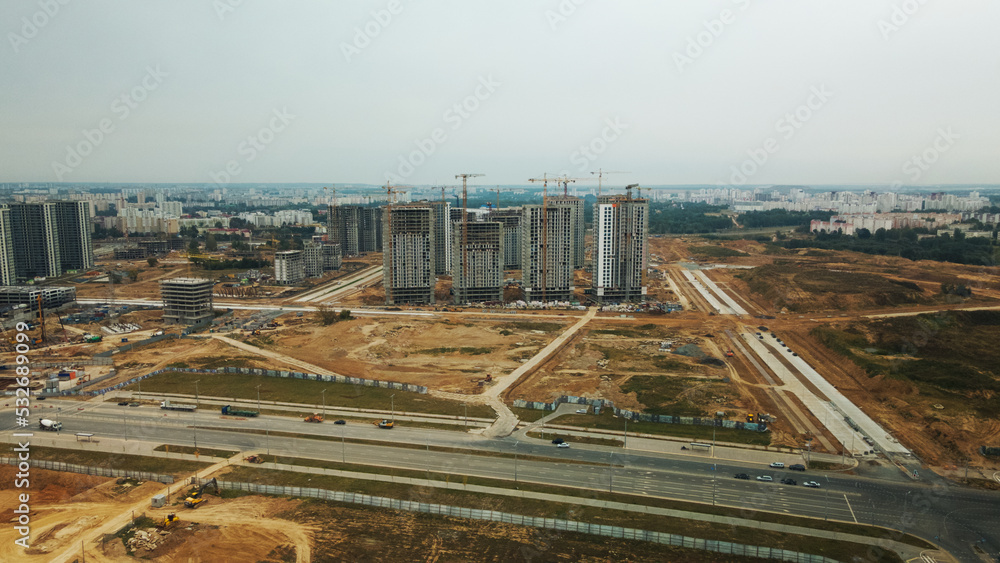 Fototapeta premium Construction site of a new city block. Construction of multi-storey buildings. Overcast weather. Aerial photography.
