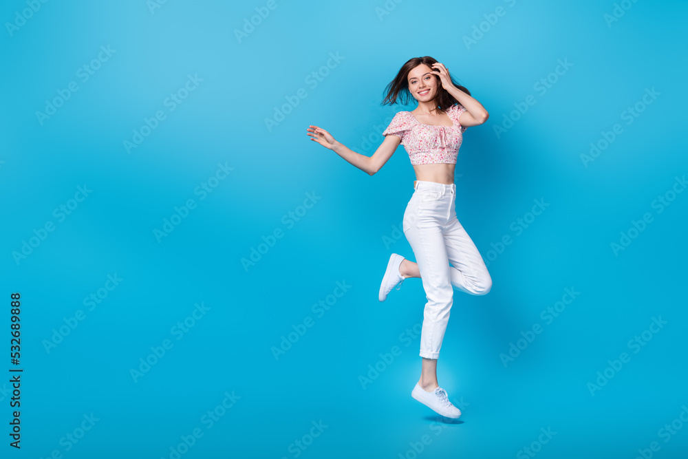 Full length photo of pretty cheery youngster lady rejoice shopping sale discount jump empty space isolated on blue background