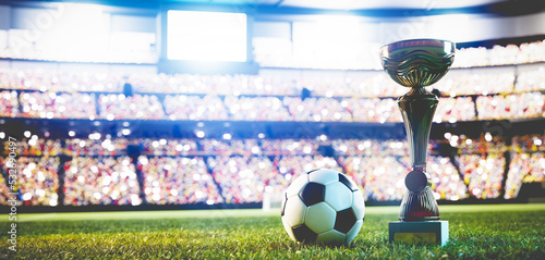 Football soccer ball and trophy cup on stadium photo