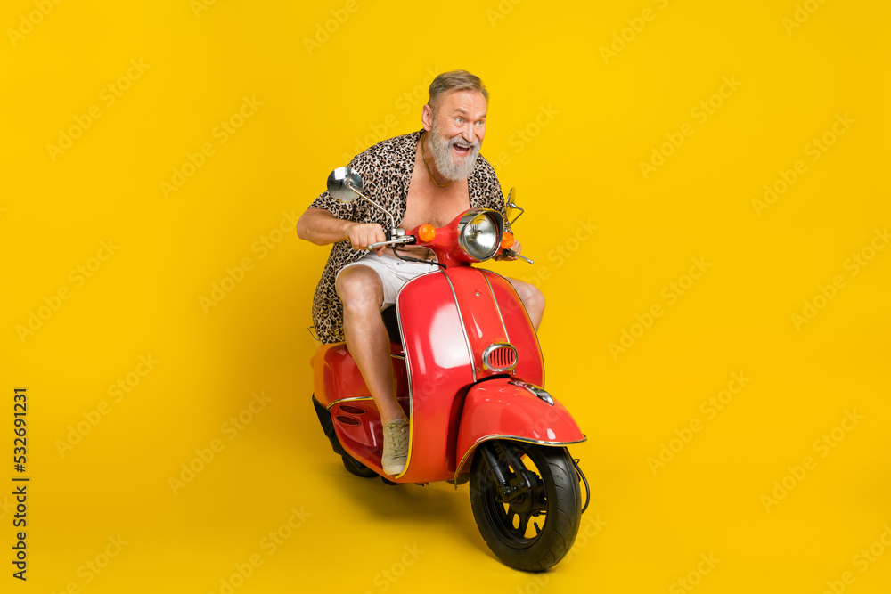 Full length portrait of overjoyed carefree person driving scooter isolated on yellow color background Full length portrait of overjoyed carefree person driving scooter isolated on yellow color background