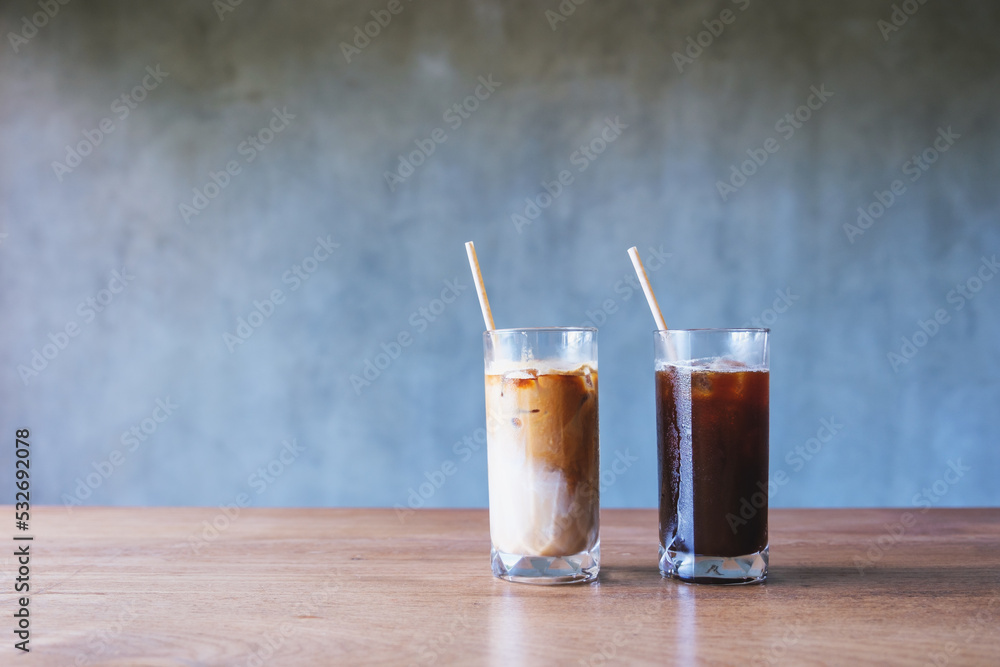 Two glasses of iced coffee with bio drinking straws on wooden table Two glasses of iced coffee with bio drinking straws on wooden table