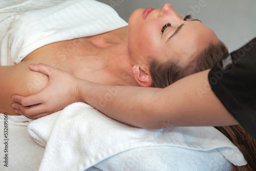 Massaging therapist makes shoulders therapy mass for woman. Massage female in SPA salon. Sensual healthy massaging in hands of professional masseur. Concept of health care and beauty. Copy text space